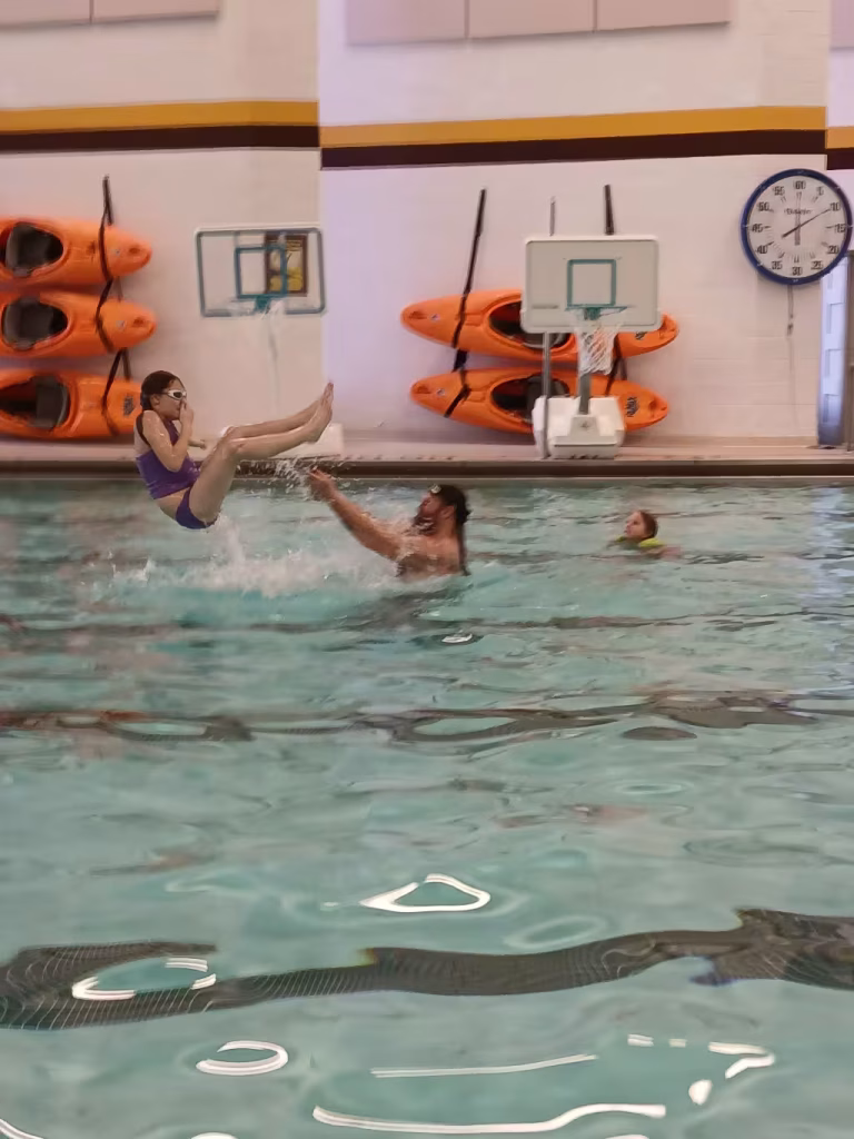 A person throwing somebody in a pool.